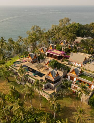 Aerial view of an eight-bedroom ocean villa at Amanpuri, Thailand, surrounded by tropical gardens and coastline.