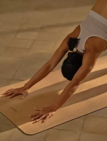 Instructor practising yoga at sunrise on mat at Amanvari resort, Laos.