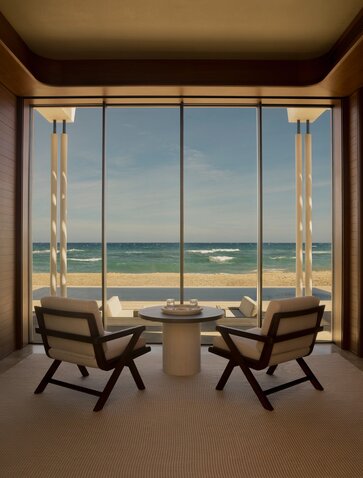 Two chairs facing expansive windows overlooking a calm sea at Amanvari, Mexico.