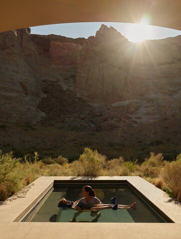 Water Shiatsu pavilion at Amangiri with mineral pool beneath desert rock formations at sunset.