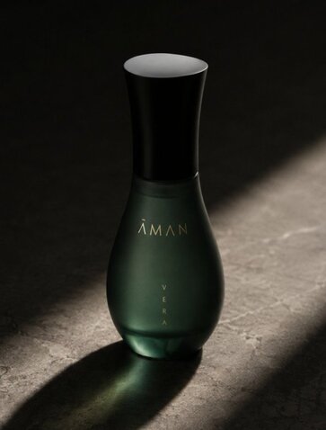 Amanvari Vera skincare bottle casting a shadow on a light surface.