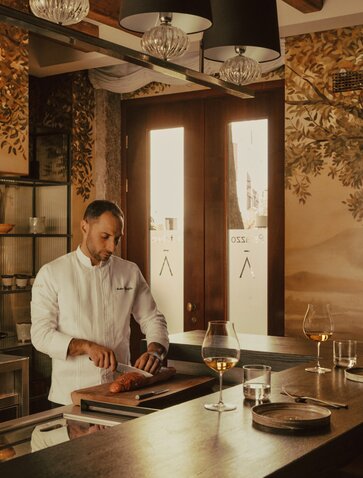 Chef preparing cuisine at the kitchen table experience at Aman Venice, Italy.