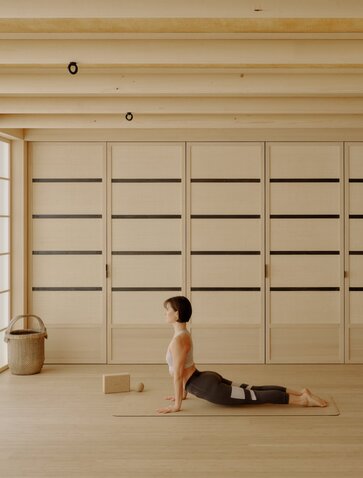 Une femme pratique le yoga dans un espace serein à Aman Le Mélézin, une station de bien-être.