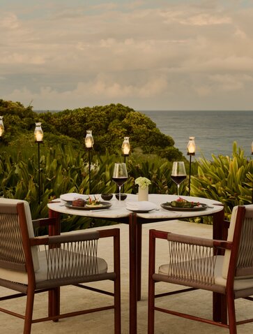 Private dining table at Amanera overlooking the Dominican Republic coastline at dusk.