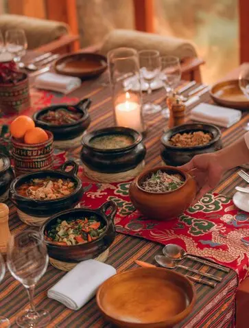Forest and stream dinner setup at Amankora, Thimphu, with traditional Bhutanese dishes and candlelit table setting.