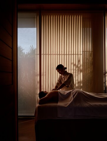 Guest receiving a spa wellness treatment at Amanvari, Mexico, bathed in warm filtered light.