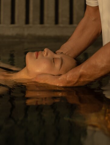 Therapist's hands massaging guest's forehead during Jinsinan Banya treatment at Amanyangyun, Shanghai.