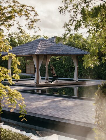 Amanyara spa and wellness pavilion overlooking tranquil waters surrounded by tropical vegetation.