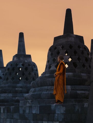 Monk in saffron robes at Borobudur temple, Amanjiwo resort, Indonesia.