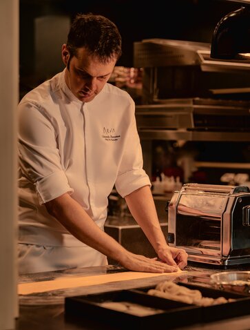 Chef preparing fresh pasta at Aman Nai Lert Bangkok's dining venue.