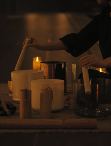 Thérapeute disposant des bougies allumées lors d'une séance de sonothérapie au spa d'Aman Tokyo.