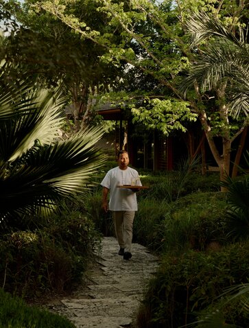 Guest walking along a shaded garden path at Amanyara, Turks and Caicos.