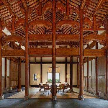 Traditional wooden pavilion interior at Amanyangyun with soaring timber beams and open-plan living space.