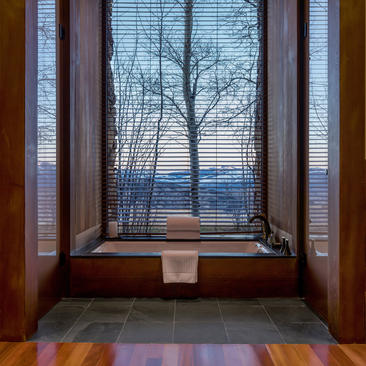 Deluxe Suite window seat at Amangani overlooking snow-covered landscape at dusk.