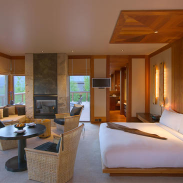 Spring Gulch Suite at Amangani with wooden furnishings, stone fireplace, and mountain views.