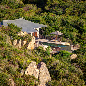 Ocean pool villa at Amanoi overlooking Vietnam's coastline, surrounded by lush green landscape.