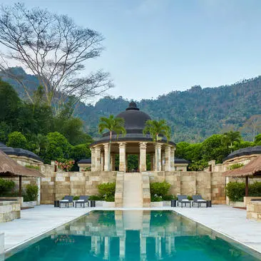 Dalem Jiwo Suite at Amanjiwo resort in Java, featuring a central pavilion with reflecting pool and verdant hillsides.