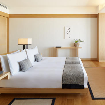 Deluxe Room at Aman Tokyo with wooden architectural framing, white bedding, and tatami flooring.