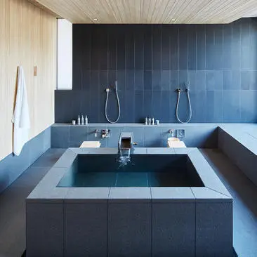 Salle de bains minimaliste avec baignoire carrée en ardoise à Amanemu.