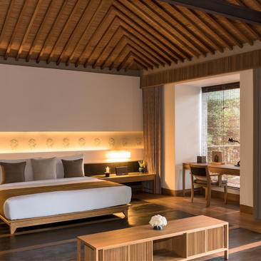 Principal bedroom at Amanoi with wooden ceiling, built-in lighting and modern furnishings overlooking Vietnam's coast.