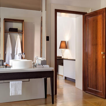 Palazzo bedroom vanity with mirror and wooden wardrobe at Aman Venice hotel.