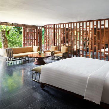 六卧花园别墅的宽敞卧室，设有现代床铺、木质屏风和花园景观，位于安缦璞瑞度假村。