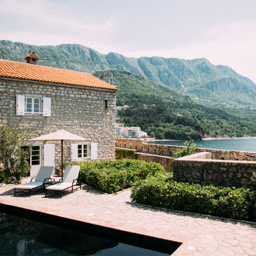 Stone suite with terrace overlooking plunge pool and mountains at Aman Sveti Stefan, Montenegro.
