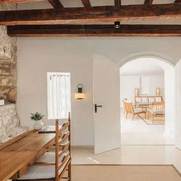 Three-bedroom village cottage at Aman Sveti Stefan, Montenegro, with arched doorway and wooden beams.