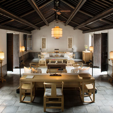 Two-bedroom villa living area at Amanfayun, featuring wooden furniture and neutral tones.