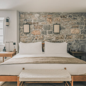 Principal bedroom with stone feature wall at Aman Sveti Stefan, Montenegro.