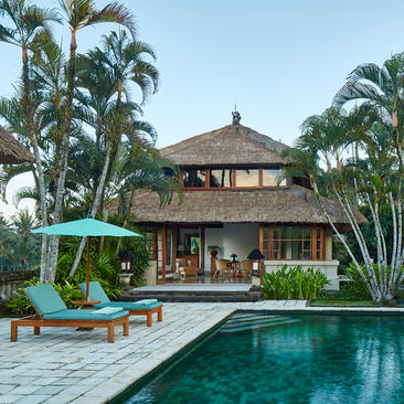 Asmara Suite at Amandari resort with plunge pool, palm trees, and traditional Balinese architecture under clear skies.