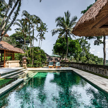 Ayung Suite pool at Amandari with thatched-roof pavilions overlooking lush Balinese gardens.