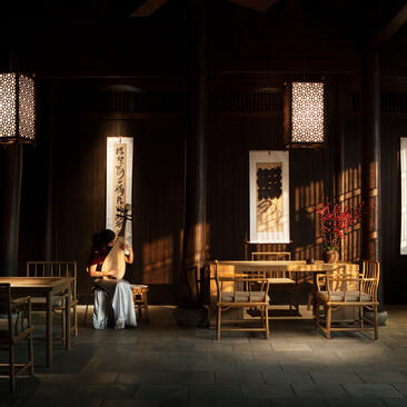 Traditional music performance space at Amanfayun, with wooden furniture and paper lanterns illuminating the dark interior.
