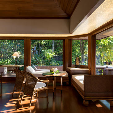 Villa quatre chambres à Amanpulo avec salon ouvert sur la forêt tropicale, mobilier en bois naturel et lumière naturelle.