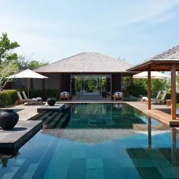 Four-bedroom ocean villa at Amanyara with infinity pool, sun loungers and thatched pavilions.
