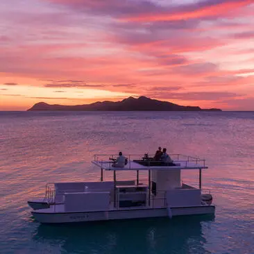 Floating dining platform at sunset, Amanpulo resort.