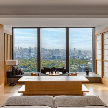 Principal bedroom with soaking tub positioned at window overlooking Tokyo's skyline at Aman Tokyo.