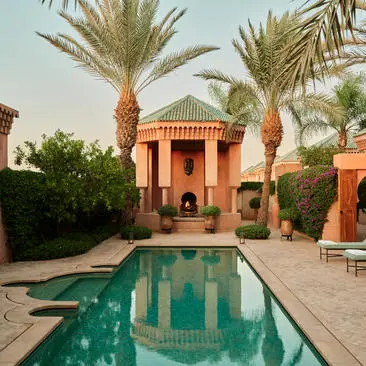 Al Hamra Suite with rectangular pool, terracotta pavilion and palm trees at Amanjena.