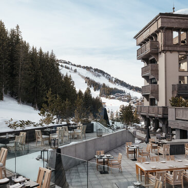 Terrace at Aman Le Mélézin with Alpine views and snow-covered landscape.