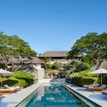 Infinity pool overlooking manicured gardens and traditional architecture at Aman Villas at Nusa Dua.
