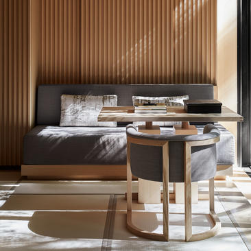 アマン京都のリゾートの客室に置かれた、黒いベッドフレームとナチュラルウッドのサイドテーブル。