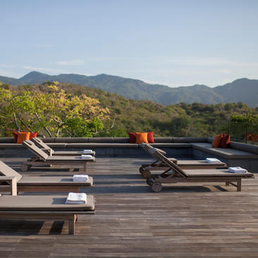 Four-bedroom villa at Amanoi with wooden deck, sun loungers, and mountain views.