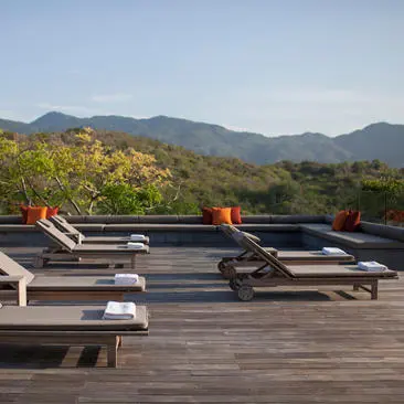 Four-bedroom villa at Amanoi with wooden deck, sun loungers, and mountain views.