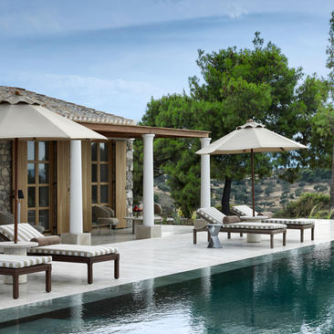 安缦卓熠度假村的泳池别墅，配备遮阳伞、躺椅及现代建筑设计。