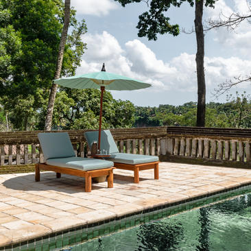 Wooden terrace at Amandari with daybed overlooking rice paddies and distant mountains.