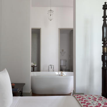 Amangalla chamber bathroom with freestanding bathtub and decorative tile floor.
