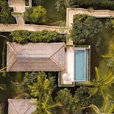 Amankila resort infinity pool suite viewed from above, with turquoise water and surrounding tropical gardens.