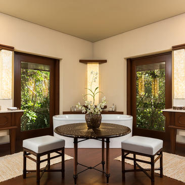 Salle de bains de la casita à Amanpulo resort, avec miroirs encadrés et mobilier en bois foncé.