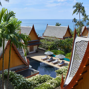 安缦璞瑞度假村鸟瞰图，展示传统泰式建筑、棕榈树及海滨景观。