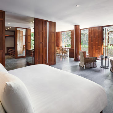 安缦璞瑞度假村的宽敞卧室，配有白色床铺和温暖的木质隔断。